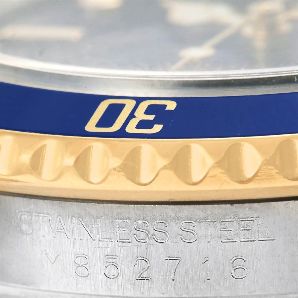 Close-up of a Rolex Submariner 16613 Men's Steel and Gold (two tone) Blue Dial 16613 Men's Steel and Gold (two tone) Blue Dial showing part of the blue and gold bezel and the engraved stainless steel case with the serial number.