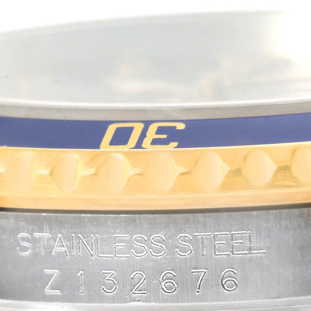 This close-up image shows the engraved serial number and part of the bezel of a Rolex Submariner 16613 Men
s Steel and Gold (two tone) Grey Dial 16613 Men
s Steel and Gold (two tone) Grey Dial watch.