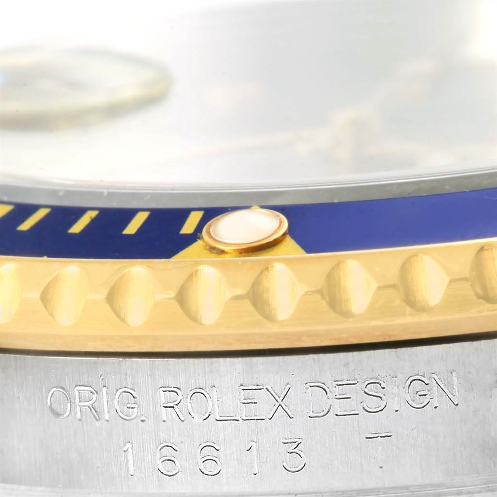 This close-up image shows the case and bezel details of a Rolex Submariner 16613 Men
s Steel and Gold (two tone) Grey Dial 16613 Men
s Steel and Gold (two tone) Grey Dial, focusing on the serial number engraving.