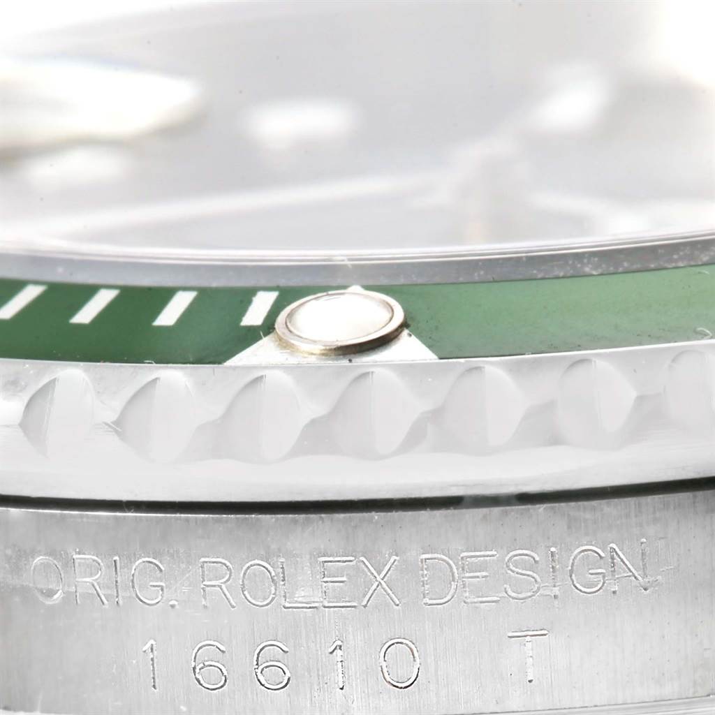 This close-up image of a Rolex Submariner 16610LV Men's Stainless Steel Black Dial 16610LV Men's Stainless Steel Black Dial watch shows the bezel and the engraved side of the case with the model number "16610 T."