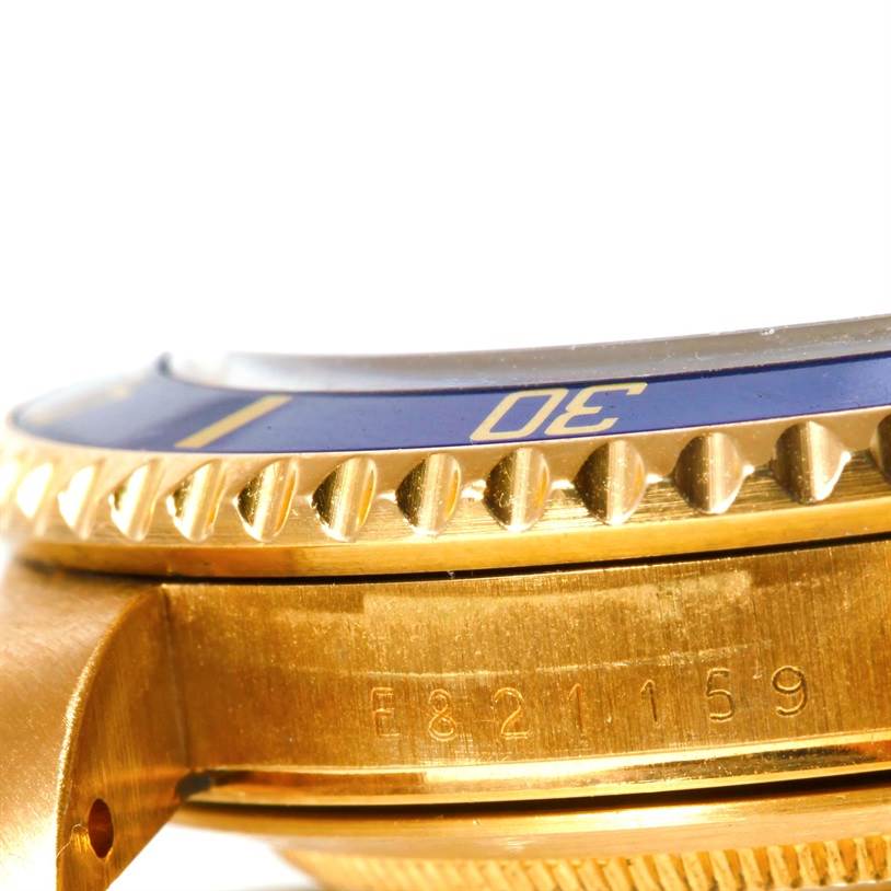 This close-up image shows the side view of the gold bezel and part of the case of a Rolex Submariner 16618 Men's Yellow Gold Blue Dial 16618 Men's Yellow Gold Blue Dial watch, with visible serial numbers.