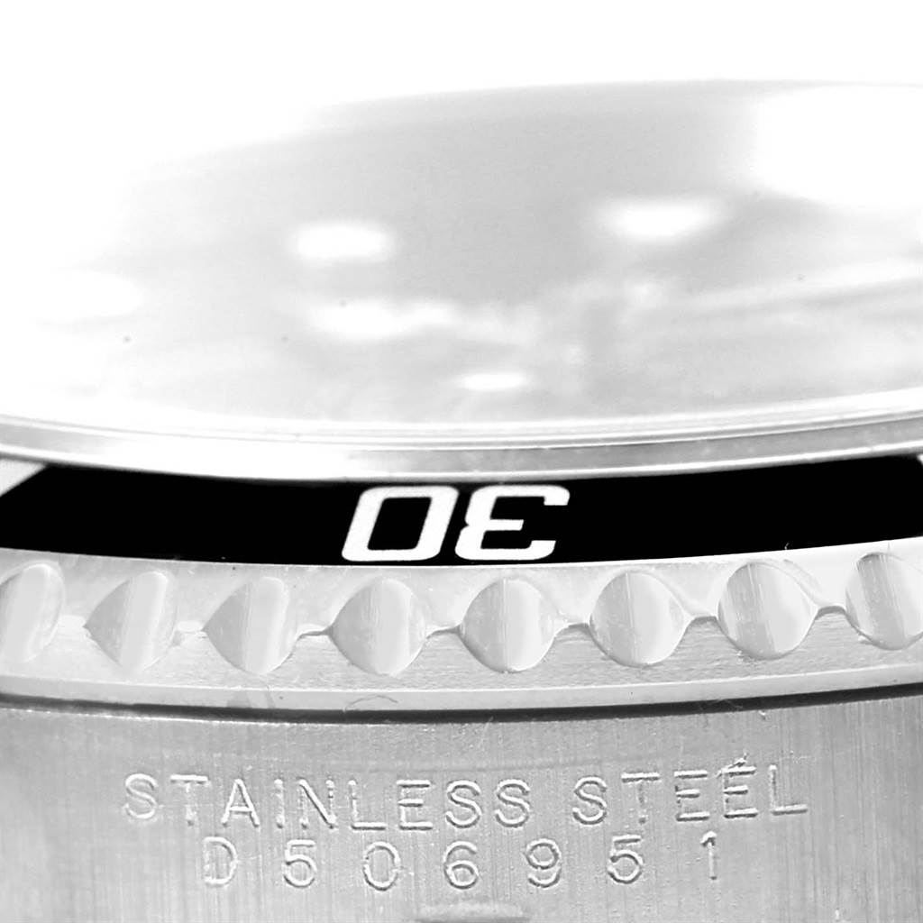 This close-up angle of a Rolex Submariner 14060 Men's Stainless Steel Black Dial 14060 Men's Stainless Steel Black Dial watch shows the bezel and part of the stainless steel case with engraved details.