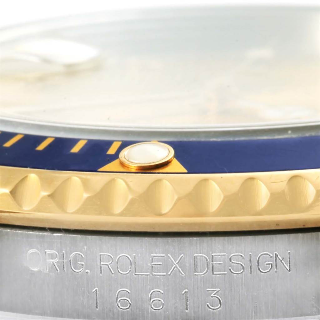 This close-up shows the side angle of the bezel and the engraved case of a Rolex Submariner 16613 Men
s Steel and Gold (two tone) Champagne Dial 16613 Men
s Steel and Gold (two tone) Champagne Dial model.