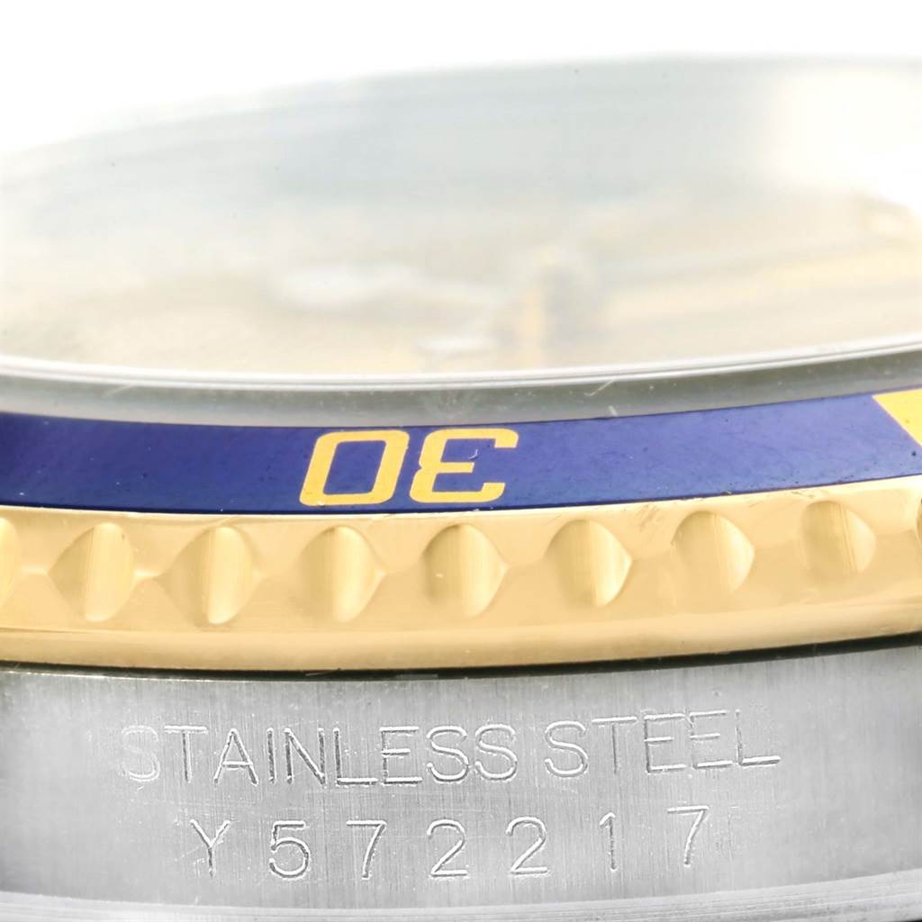 The image shows a close-up of the bezel and part of the case of a Rolex Submariner 16613 Men
s Steel and Gold (two tone) Champagne Dial 16613 Men
s Steel and Gold (two tone) Champagne Dial watch, highlighting the "30" mark and the "Stainless Steel" engraving.