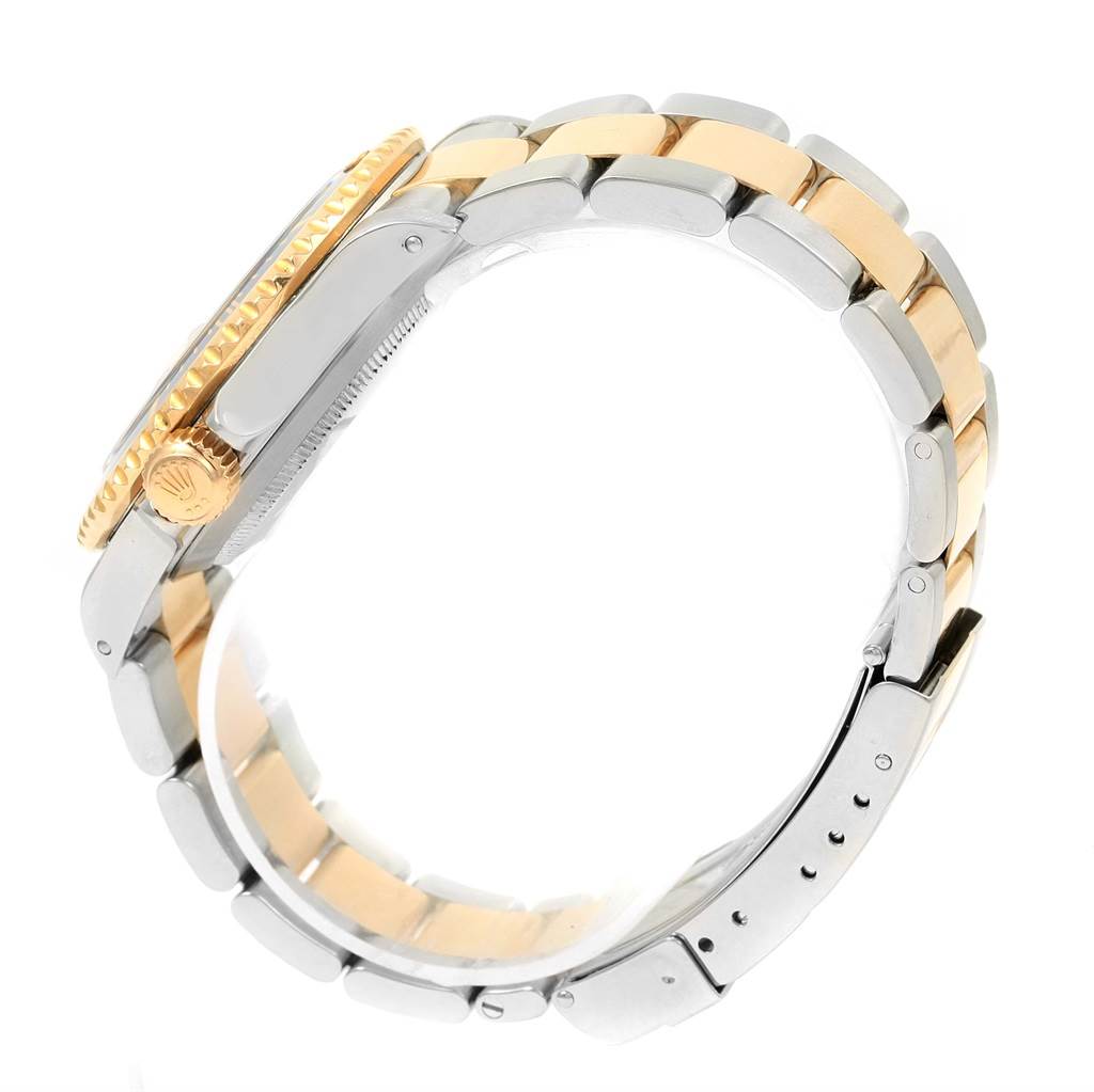 The image shows a side view of a Rolex Submariner 16613 Men
s Steel and Gold (two tone) Champagne Dial 16613 Men
s Steel and Gold (two tone) Champagne Dial, highlighting the crown, bezel, and two-tone bracelet.