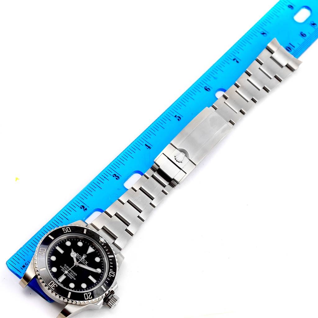 The image shows a Rolex Submariner 114060 Men's Stainless Steel Black Dial 114060 Men's Stainless Steel Black Dial watch laid flat alongside a blue ruler, displaying the wristband and face.