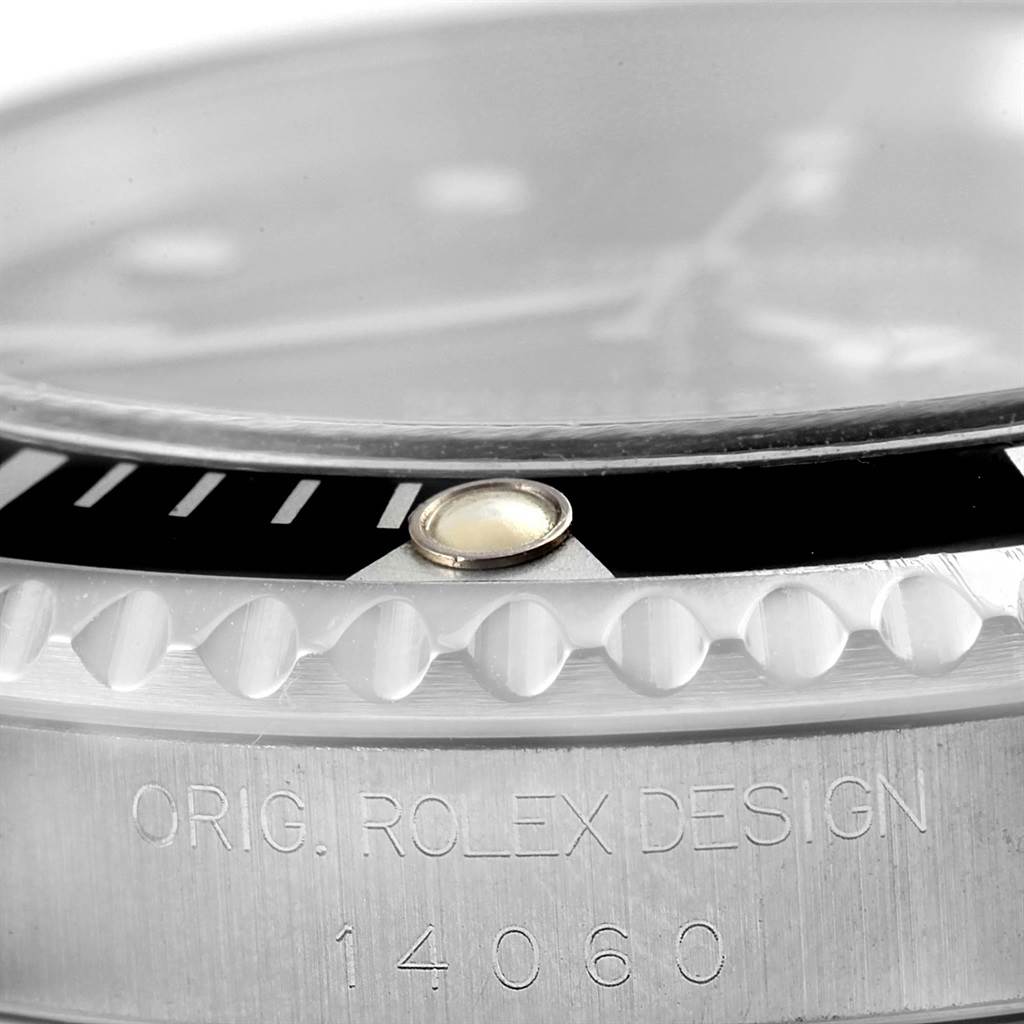 This image shows a close-up of the bezel, crystal, and case side of a Rolex Submariner 14060 Men
s Stainless Steel Black Dial 14060 Men
s Stainless Steel Black Dial model, highlighting the engraving "ORIG. ROLEX DESIGN 14060".