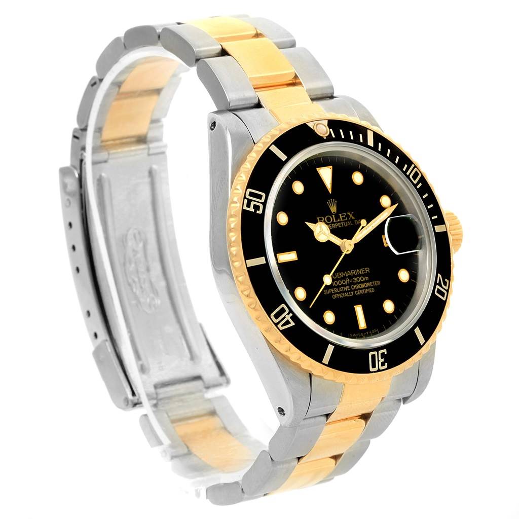 The image shows a Rolex Submariner 16803 Men
s Steel and Gold (two tone) Black Dial 16803 Men
s Steel and Gold (two tone) Black Dial watch from a three-quarter angle, highlighting the black dial, gold bezel, and two-tone strap.