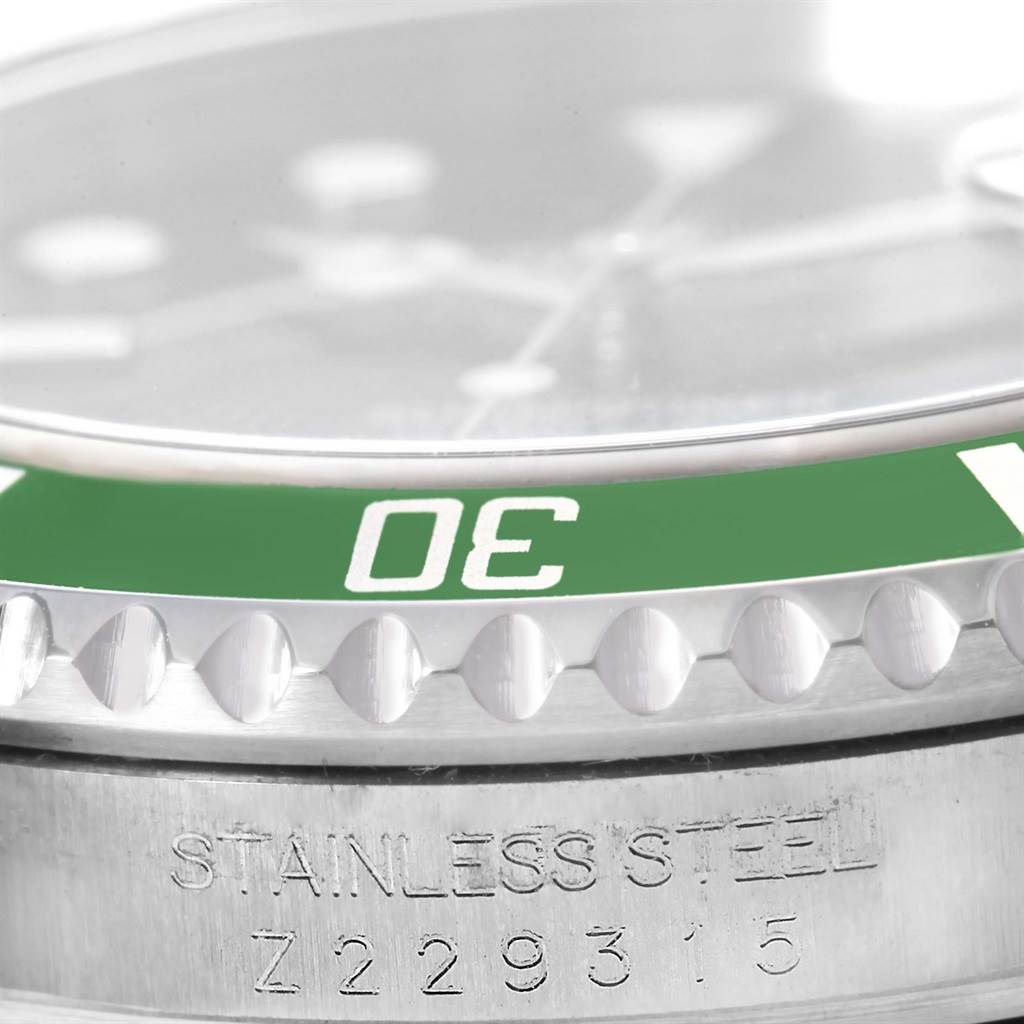 Close-up of a Rolex Submariner 16610LV Men's Stainless Steel Black Dial 16610LV Men's Stainless Steel Black Dial showing the green bezel, part of the dial, and the engraving "STAINLESS STEEL Z229315" on the case.