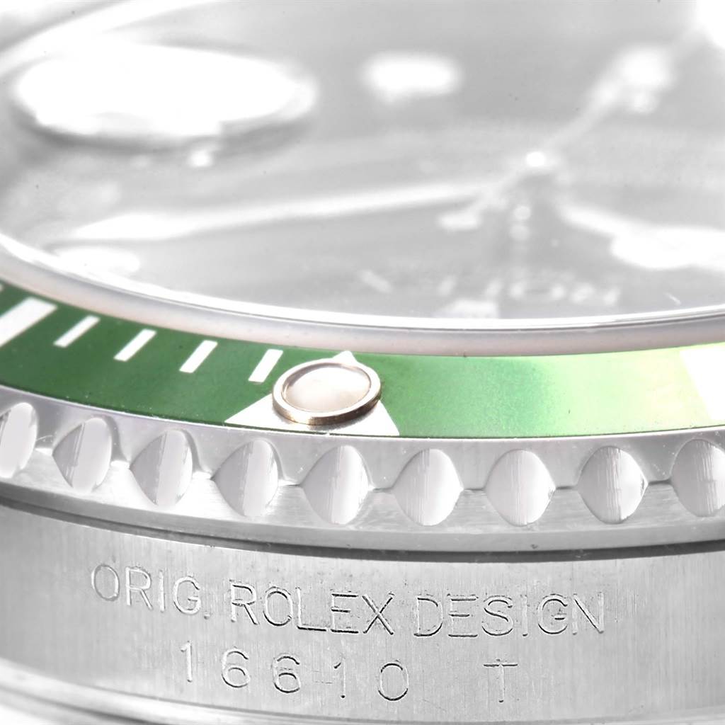 Close-up of a Rolex Submariner 16610LV Men's Stainless Steel Black Dial 16610LV Men's Stainless Steel Black Dial, showing the green bezel, cyclops lens, and engraved side with the design number 16610.