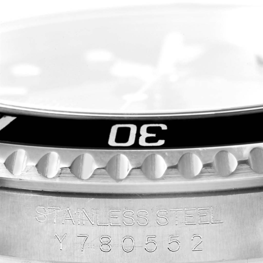 The image shows a close-up of the bezel and part of the stainless steel case of a Rolex Submariner 16610 Men's Stainless Steel Black Dial 16610 Men's Stainless Steel Black Dial watch.