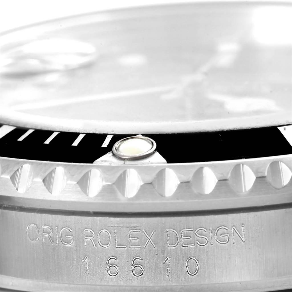 This close-up image of the Rolex Submariner 16610 Men's Stainless Steel Black Dial 16610 Men's Stainless Steel Black Dial shows the bezel, crystal, and engraved model number on the case side.