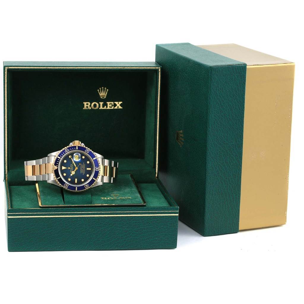 The Rolex Submariner 16803 Men's Steel and Gold (two tone) Blue Dial 16803 Men's Steel and Gold (two tone) Blue Dial watch is displayed frontally in its green and gold box.