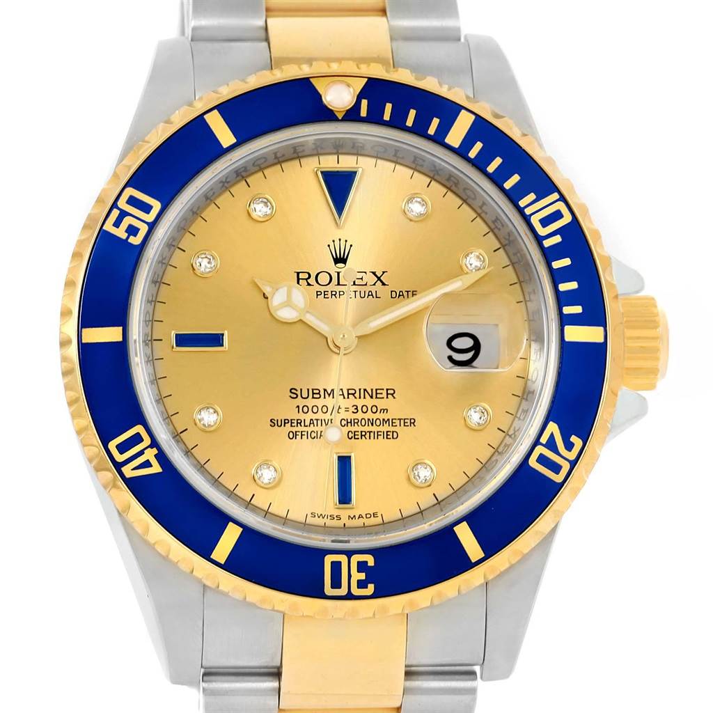 The image shows a frontal view of a Rolex Submariner 16613 Men's Steel and Gold (two tone) Champagne Dial 16613 Men's Steel and Gold (two tone) Champagne Dial watch, displaying its blue and gold bezel, gold dial, and date window.