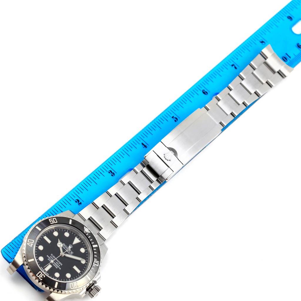 The image shows a Rolex Submariner 114060 Men's Stainless Steel Black Dial 114060 Men's Stainless Steel Black Dial watch laid flat next to a ruler, displaying the face and full bracelet.