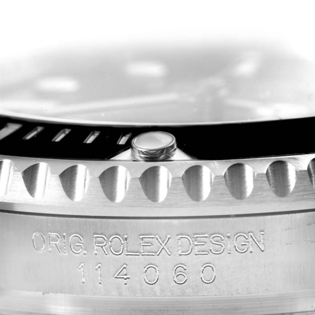 The image shows a close-up angle of a Rolex Submariner 114060 Men's Stainless Steel Black Dial 114060 Men's Stainless Steel Black Dial's bezel, focusing on the serrated edges and model number 114060.