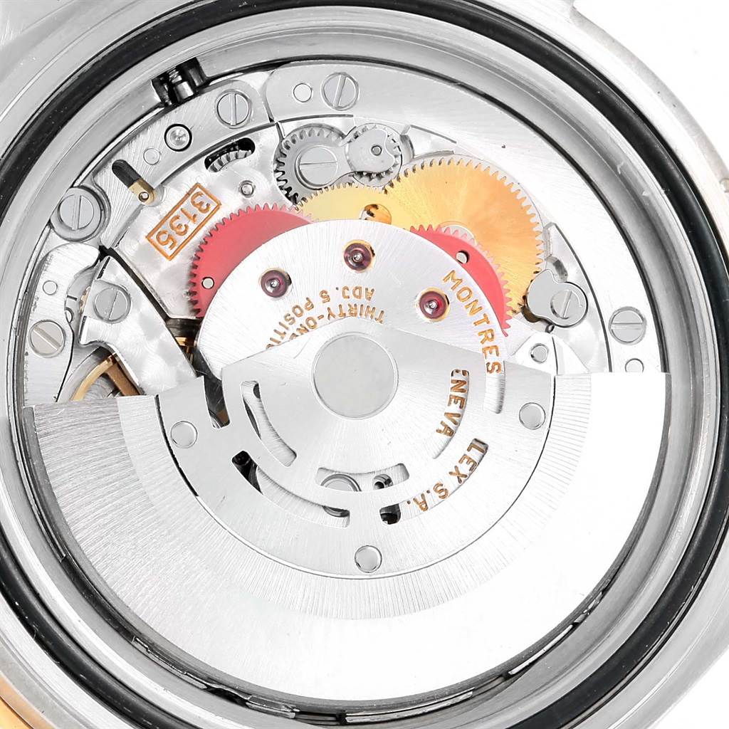 The image shows a close-up, top view of the Rolex Submariner 16613 Men
s Steel and Gold (two tone) Blue Dial 16613 Men
s Steel and Gold (two tone) Blue Dial watch
s intricate internal movement and gears.