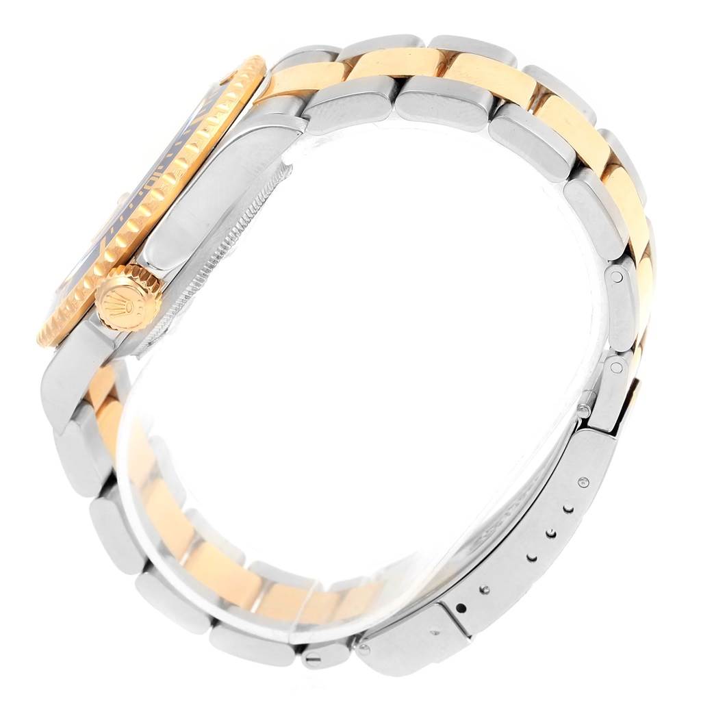 The image shows a side view of a Rolex Submariner 16613 Men
s Steel and Gold (two tone) Grey Dial 16613 Men
s Steel and Gold (two tone) Grey Dial watch, highlighting its bracelet, crown, and bezel.