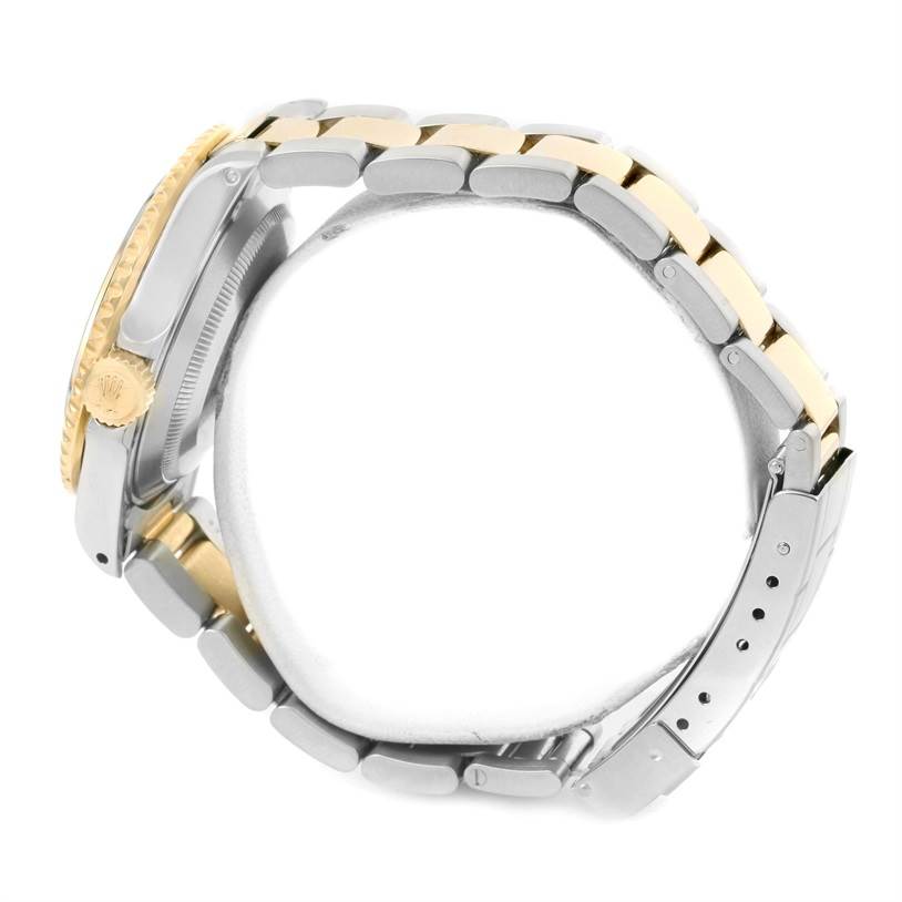 The image shows a side view of a Rolex Submariner 16613 Men's Steel and Gold (two tone) Champagne Dial 16613 Men's Steel and Gold (two tone) Champagne Dial, highlighting its two-tone metal bracelet and crown.