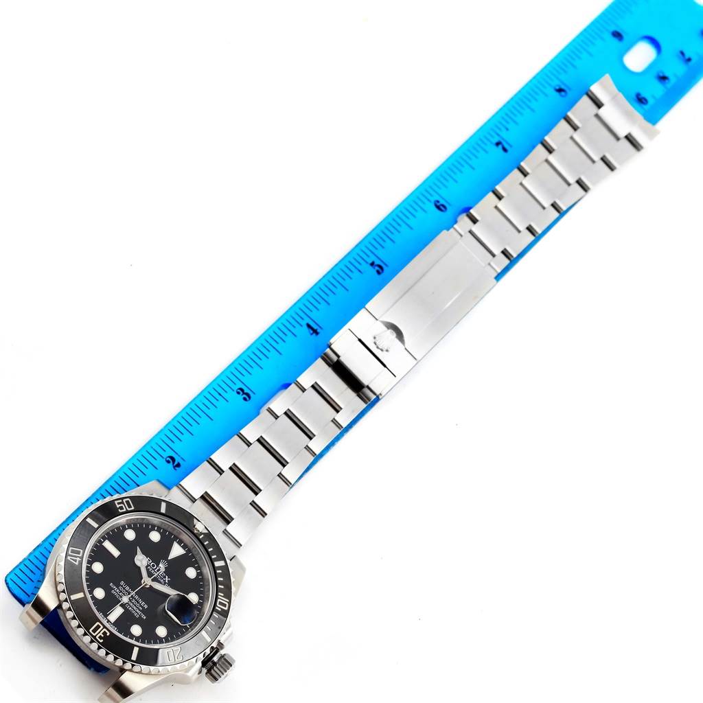 The image shows a Rolex Submariner 116610 Men's Stainless Steel Black Dial 116610 Men's Stainless Steel Black Dial watch laid flat next to a ruler, displaying both the watch face and metal bracelet.