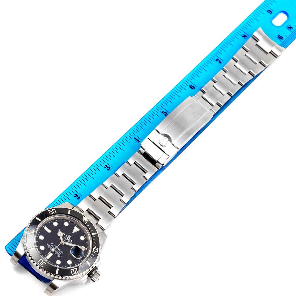 This image shows a top-down view of a Rolex Submariner 116610 Men's Stainless Steel Black Dial 116610 Men's Stainless Steel Black Dial watch, displaying the dial, bezel, bracelet, and clasp alongside a ruler for scale.