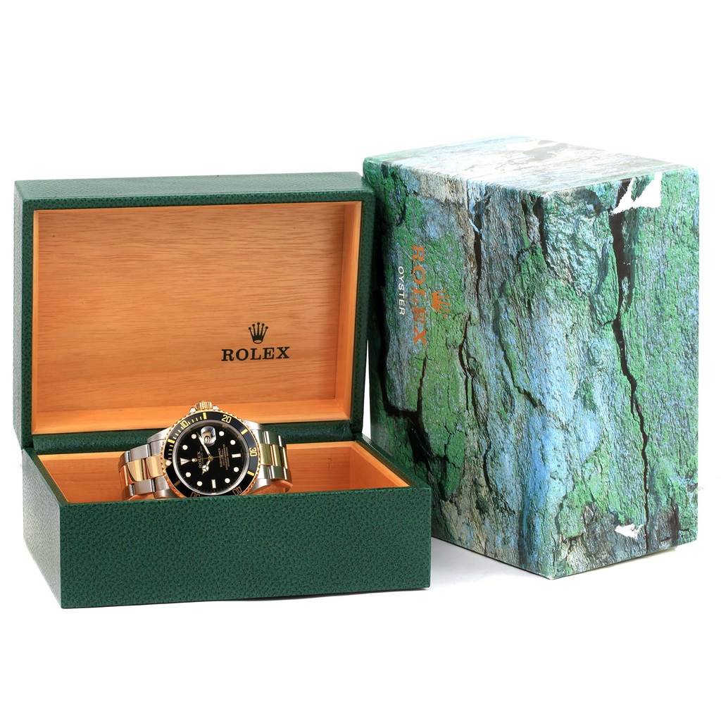 The image shows a Rolex Submariner 16613 Men's Stainless Steel Black Dial 16613 Men's Stainless Steel Black Dial watch in an open green and wood Rolex box with a textured green outer box beside it.