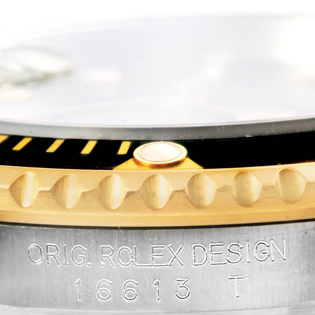 This close-up image shows the edge of the bezel and part of the case with engraved details of the Rolex Submariner 16613 Men's Stainless Steel Black Dial 16613 Men's Stainless Steel Black Dial model 16613.