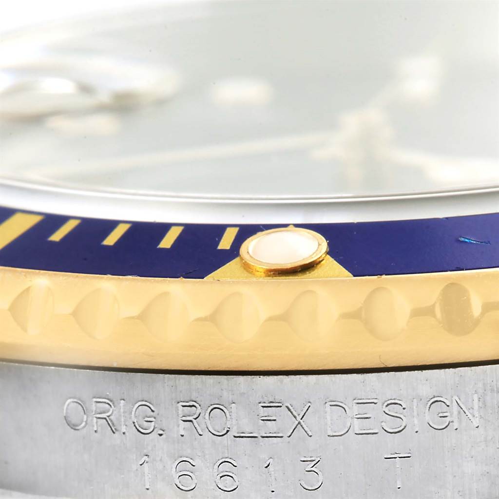 This close-up angle displays the bezel and part of the engraving on the case of the Rolex Submariner 16613 Men's Steel and Gold (two tone) Blue Dial 16613 Men's Steel and Gold (two tone) Blue Dial model 16613.