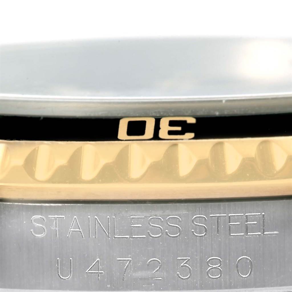 The image shows a close-up of the bezel and case edge of a Rolex Submariner 16613 Men
s Steel and Gold (two tone) Black Dial 16613 Men
s Steel and Gold (two tone) Black Dial watch, highlighting the stainless steel and part of the serial number.