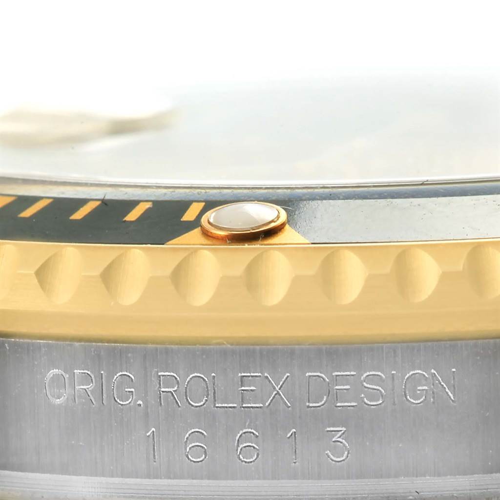 This close-up image shows the edge of the bezel, a pearl marker, and engraving on a Rolex Submariner 16613 Men's Steel and Gold (two tone) Champagne Dial 16613 Men's Steel and Gold (two tone) Champagne Dial watch.