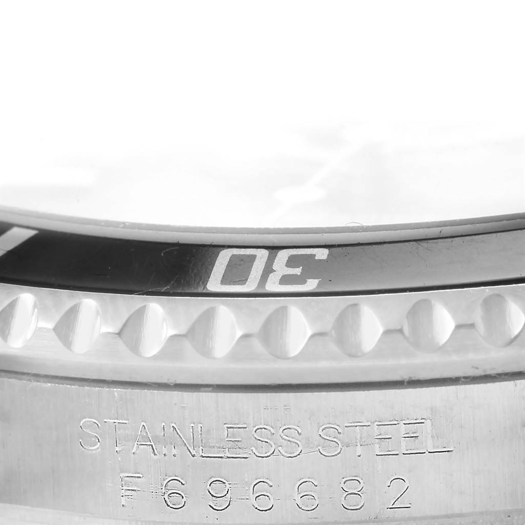 The image shows a close-up of the bezel and part of the case back of a Rolex Submariner 16610 Men's Stainless Steel Black Dial 16610 Men's Stainless Steel Black Dial watch.