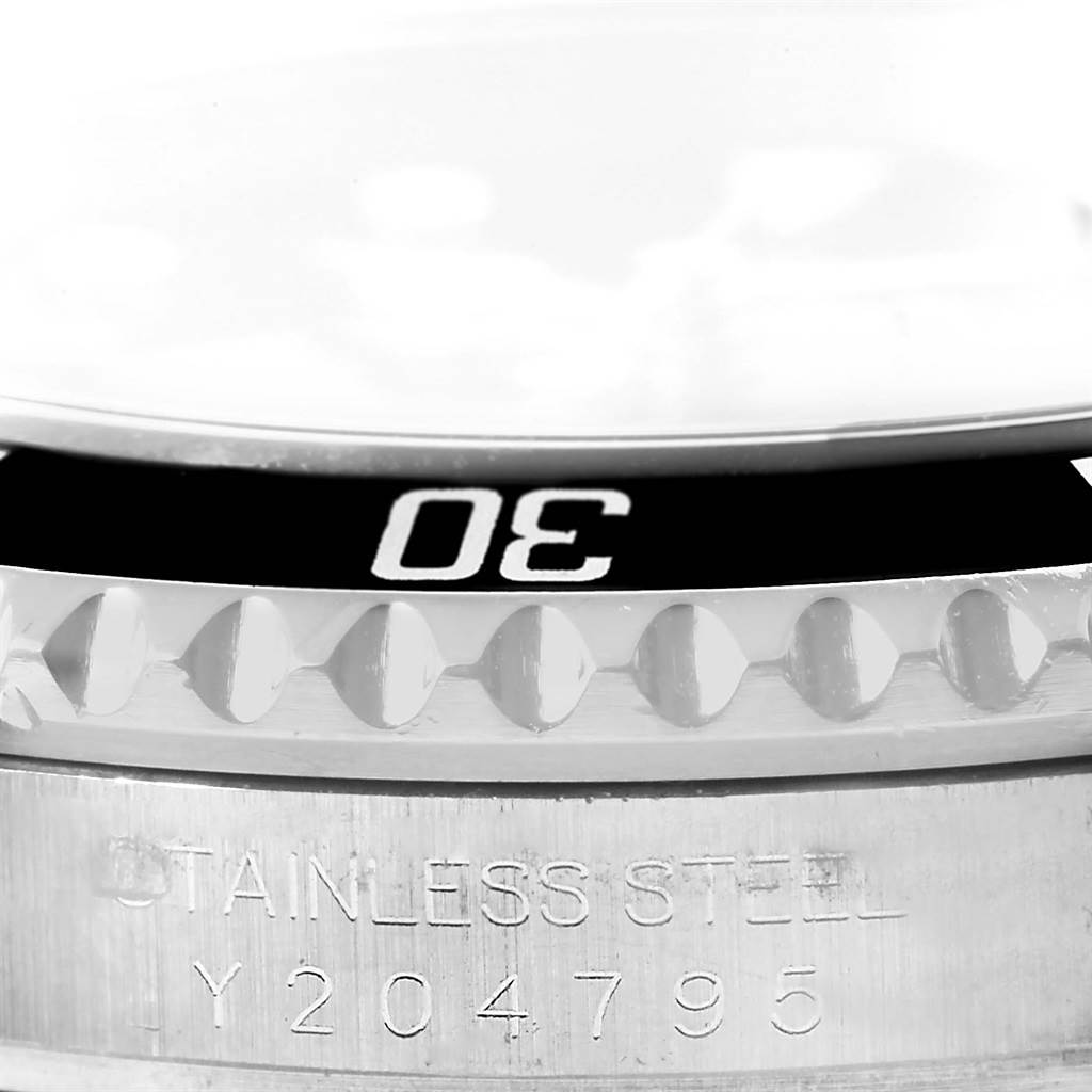 This close-up image shows the bezel and part of the engraved case back of a Rolex Submariner 16610 Men's Stainless Steel Black Dial 16610 Men's Stainless Steel Black Dial watch.