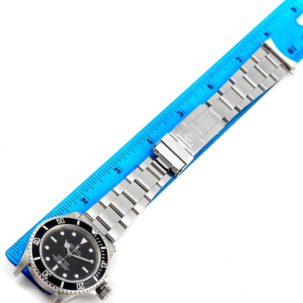 The image shows a top-view angle of a Rolex Submariner 14060 Men's Stainless Steel Black Dial 14060 Men's Stainless Steel Black Dial's face and bracelet, measured against a blue ruler.
