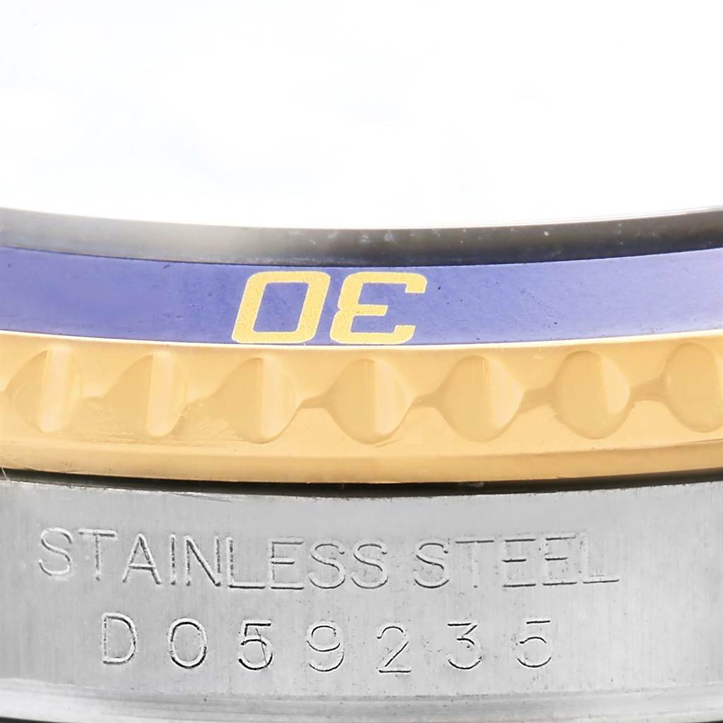 Close-up of the watch case back and engraved serial number of a Rolex Submariner 16613 Men's Steel and Gold (two tone) Blue Dial 16613 Men's Steel and Gold (two tone) Blue Dial, along with part of the bezel.