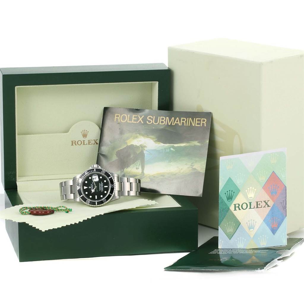 The image shows a Rolex Submariner 16610 Men's Stainless Steel Black Dial 16610 Men's Stainless Steel Black Dial watch, its box, manuals, and other accessories from a front angle.