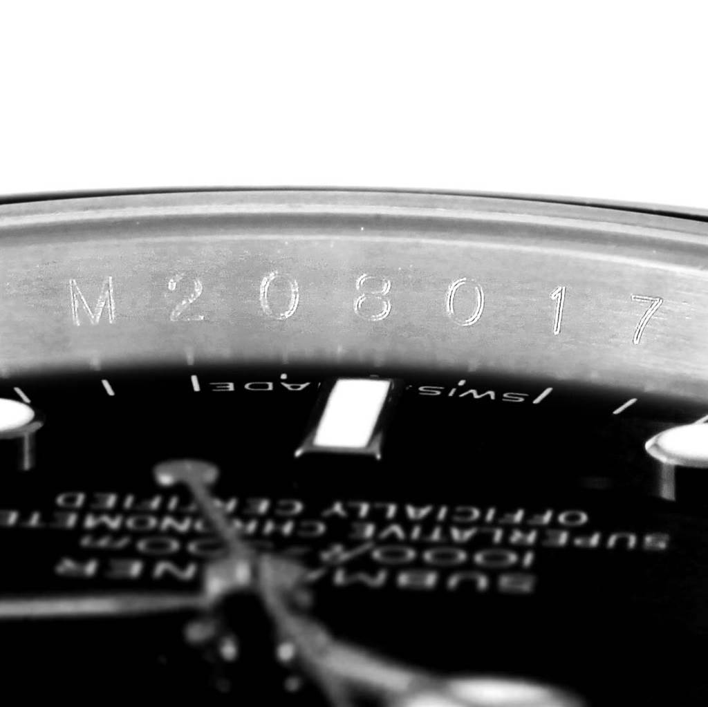The image shows a close-up of the serial number and part of the dial of a Rolex Submariner 14060 Men's Stainless Steel Black Dial 14060 Men's Stainless Steel Black Dial watch.