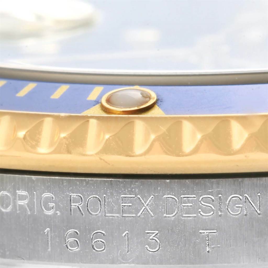 Close-up of a Rolex Submariner 16613 Men's Steel and Gold (two tone) Blue Dial 16613 Men's Steel and Gold (two tone) Blue Dial showing the bezel, markers, and engraved model number 16613 on the side.