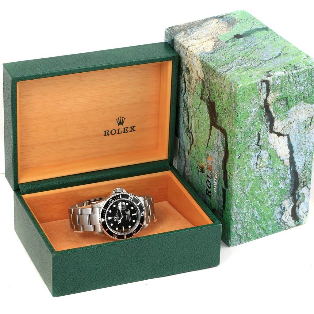 The Rolex Submariner 16610 Men's Stainless Steel Black Dial 16610 Men's Stainless Steel Black Dial watch is shown inside its open presentation box, angled diagonally with the box's lid open.