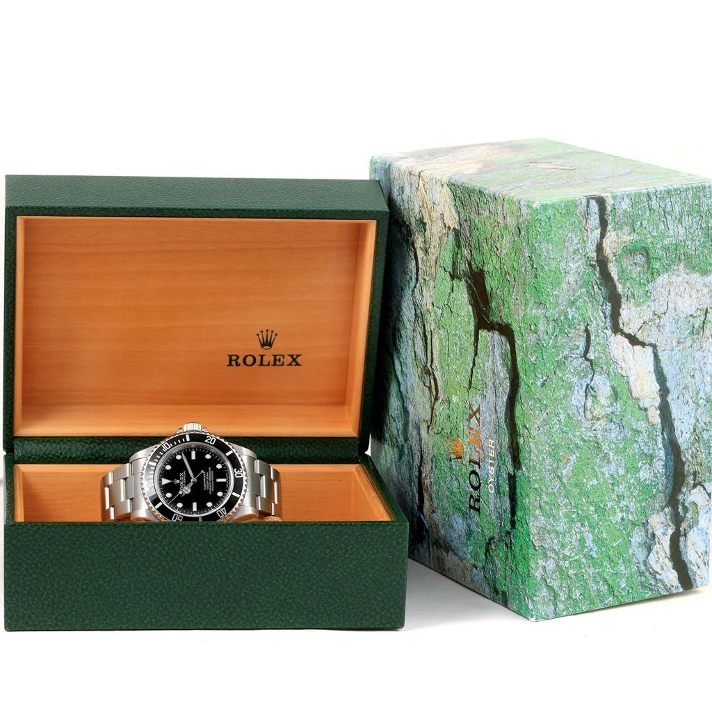 This image shows a Rolex Submariner 14060 Men's Stainless Steel Black Dial 14060 Men's Stainless Steel Black Dial watch displayed in an open green and wood Rolex box with a green outer box beside it.