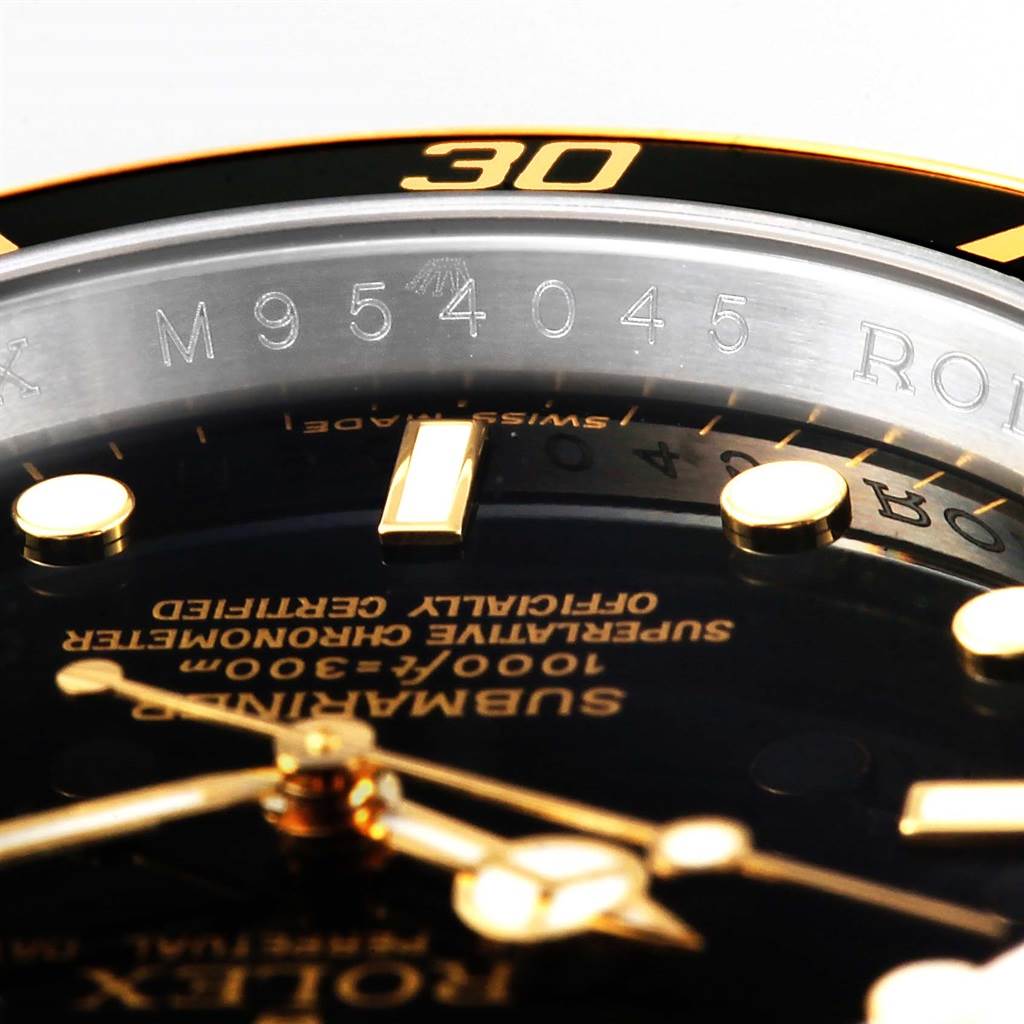 The image shows a close-up of the bezel, dial, and serial number engraving on a Rolex Submariner 16613 Men
s Steel and Gold (two tone) Black Dial 16613 Men
s Steel and Gold (two tone) Black Dial watch.