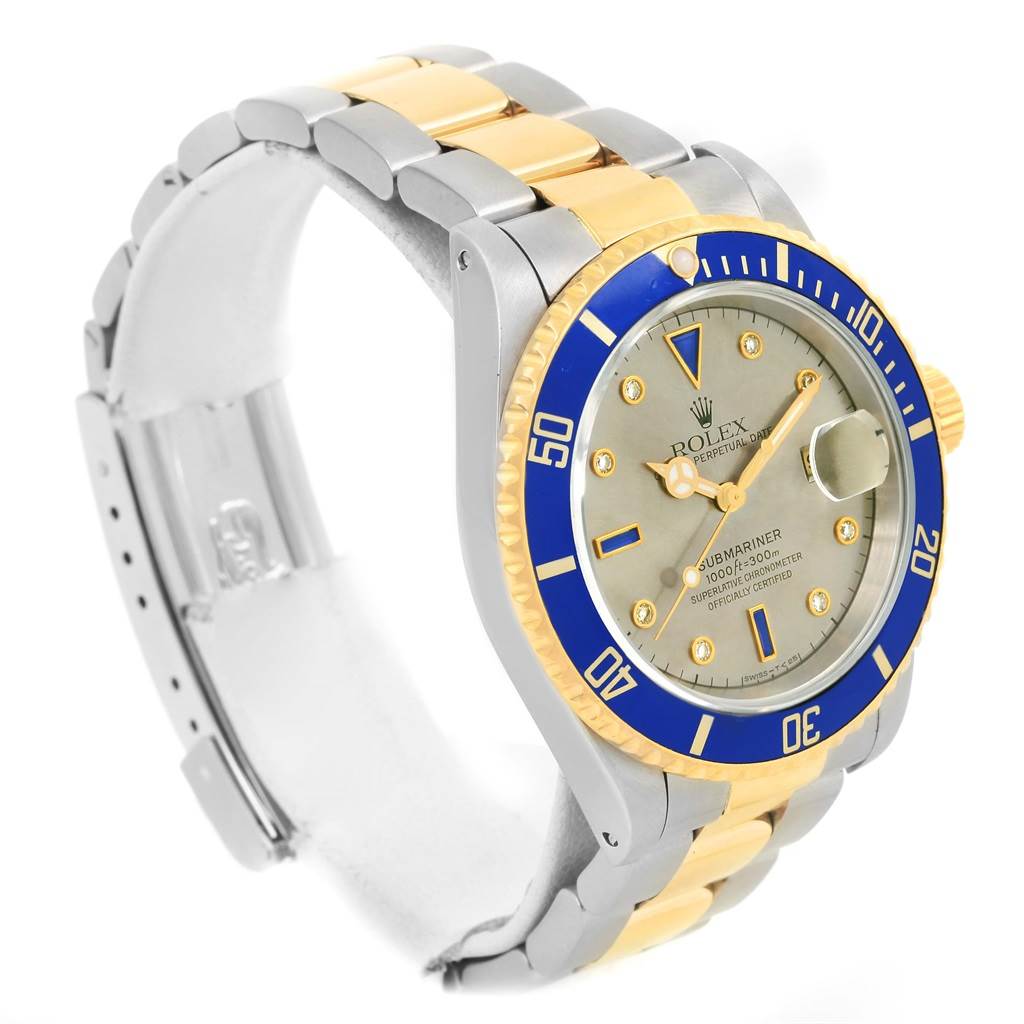 The image shows a Rolex Submariner 16613 Men's Steel and Gold (two tone) Grey Dial 16613 Men's Steel and Gold (two tone) Grey Dial watch at a three-quarter angle, highlighting the bezel, dial, and bracelet.