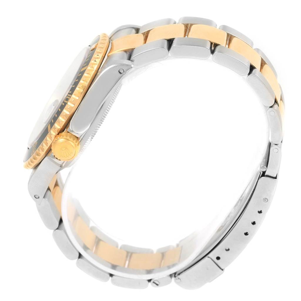 The image shows a side view of a Rolex Submariner 16613 Men
s Steel and Gold (two tone) Black Dial 16613 Men
s Steel and Gold (two tone) Black Dial watch focusing on the crown, bezel, and two-tone bracelet.