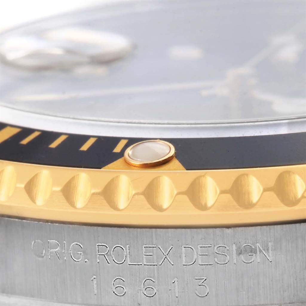 This image shows a close-up of the bezel, crystal, and engraving on a Rolex Submariner 16613 Men
s Steel and Gold (two tone) Black Dial 16613 Men
s Steel and Gold (two tone) Black Dial watch.