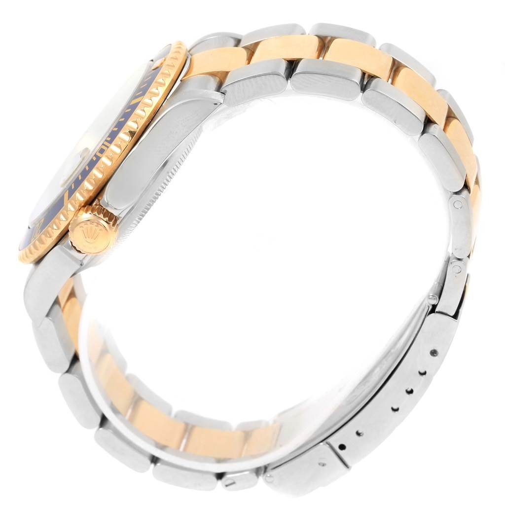 This image shows a side angle of a Submariner model by Rolex, highlighting the crown, bezel, and two-tone bracelet.