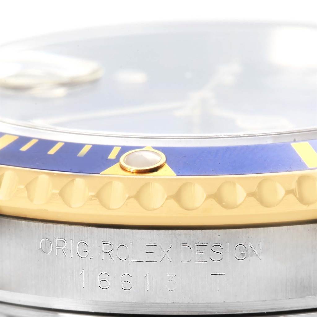 This image shows a close-up of the bezel and side case of a Rolex Submariner 16613 Men's Steel and Gold (two tone) Blue Dial 16613 Men's Steel and Gold (two tone) Blue Dial watch with the model number 16613.