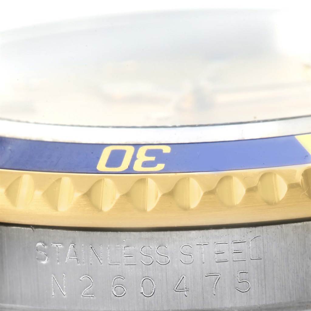 This image shows a close-up of the bezel and the stainless steel casing of a Rolex Submariner 16613 Men's Steel and Gold (two tone) Champagne Dial 16613 Men's Steel and Gold (two tone) Champagne Dial watch.