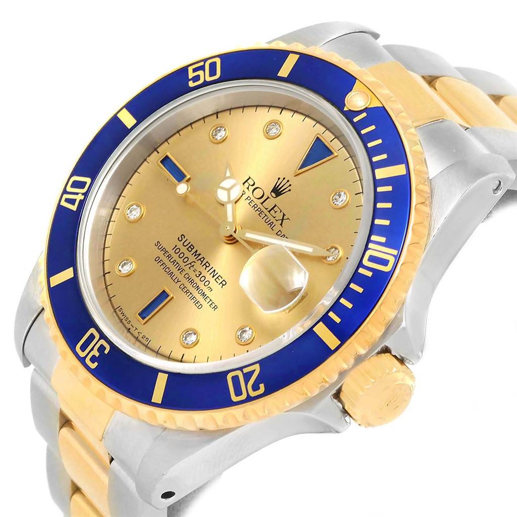 The image shows a close-up of the Rolex Submariner 16613 Men's Steel and Gold (two tone) Champagne Dial 16613 Men's Steel and Gold (two tone) Champagne Dial watch at an angle highlighting the gold dial, blue bezel, and parts of the bracelet.
