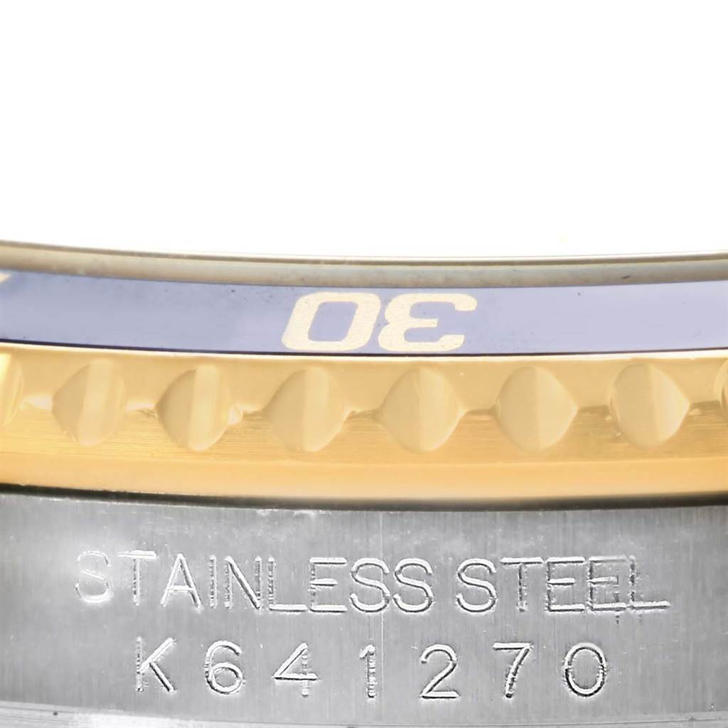 Close-up of the bezel and the case side of a Rolex Submariner 16613 Men's Steel and Gold (two tone) Blue Dial 16613 Men's Steel and Gold (two tone) Blue Dial watch, showing part of the 30-minute marker and the model's serial number.