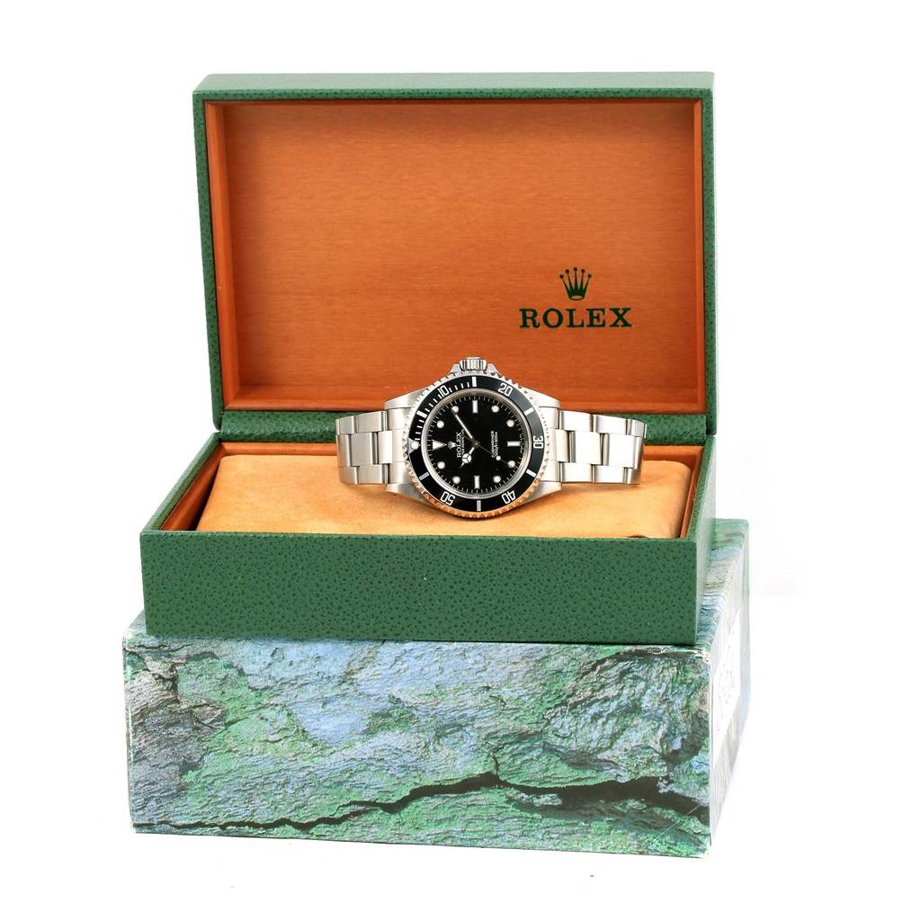 The Rolex Submariner 14060 Men's Stainless Steel Black Dial 14060 Men's Stainless Steel Black Dial watch is displayed front-on inside its green and orange branded box.