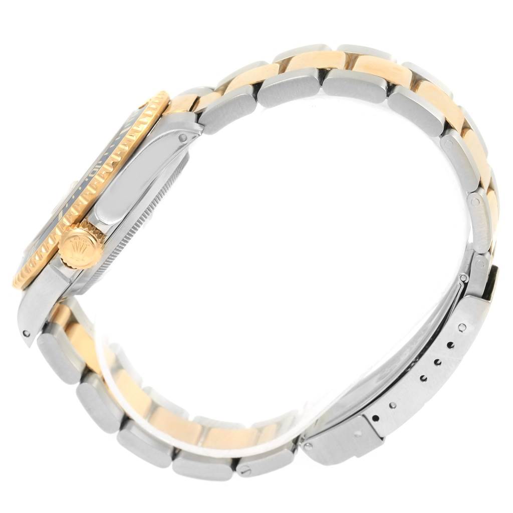 This Rolex Submariner 16613 Men's Steel and Gold (two tone) Blue Dial 16613 Men's Steel and Gold (two tone) Blue Dial watch is shown from a side angle, highlighting its bracelet, clasp, and crown.